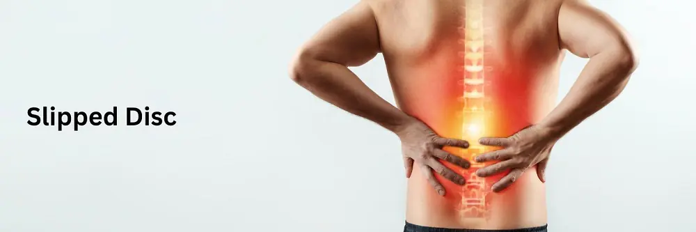 A man grimacing in pain, holding his lower back.