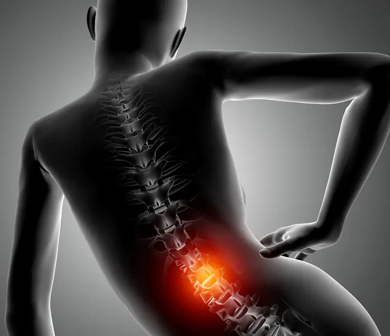 A woman hunched forward with her hands on her lower back